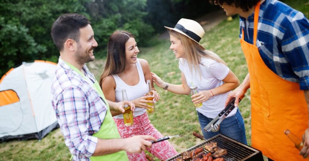 Group of friends camping and having a barbecue.